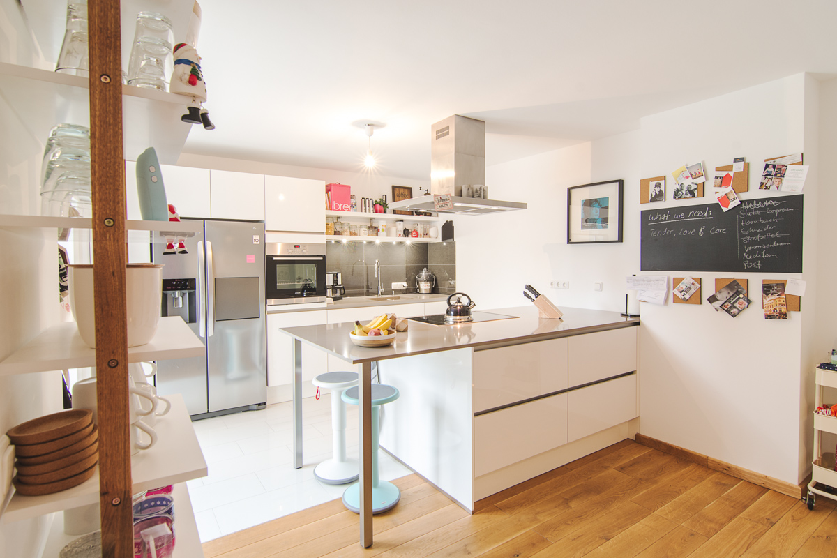Weiße Designerküche mit hellbrauner Sitzecke und hochwertigen Elektrogeräten, Fotos aus der Galerie