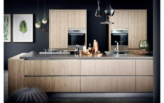 Hellbraune Küche mit schwarzer Arbeitsplatte in dunklem Raum