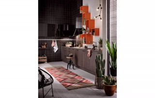 Designerküche mit Eichenfronten und orangenem Wandregal und buntem Teppich