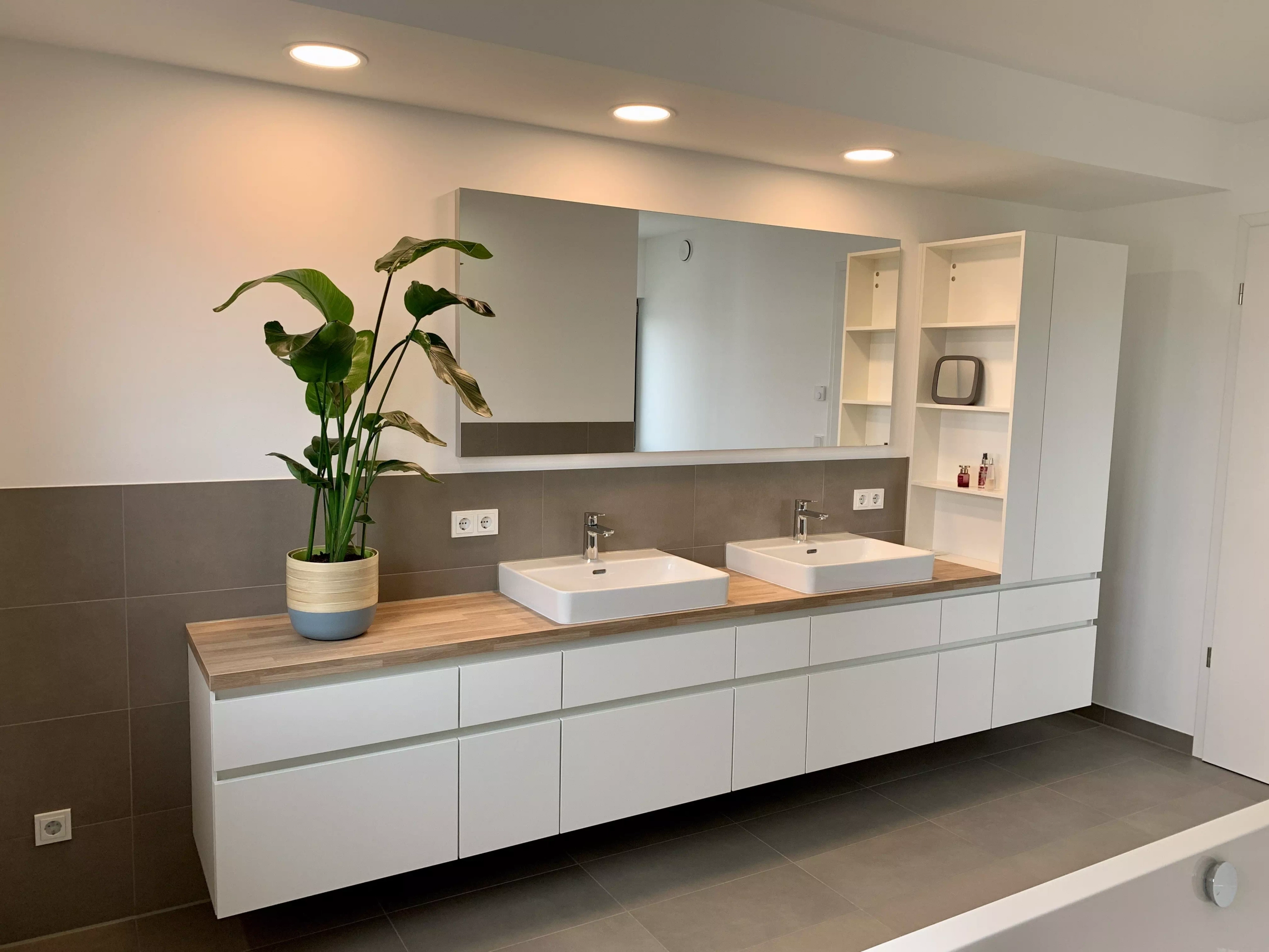 Moderne, weiße Badezimmerschränke mit Holzakzenten und Waschbecken, in Küchenqualität